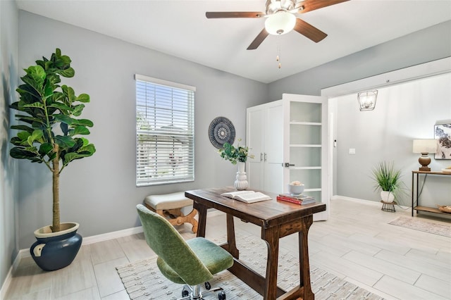 office area with a ceiling fan and baseboards