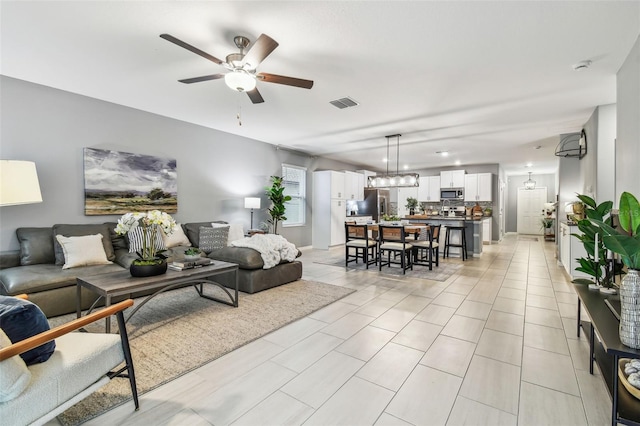 living room featuring visible vents and a ceiling fan