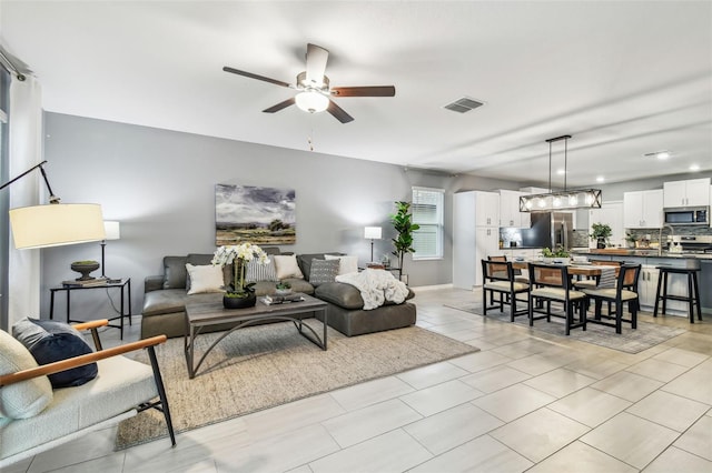 living area with visible vents and a ceiling fan