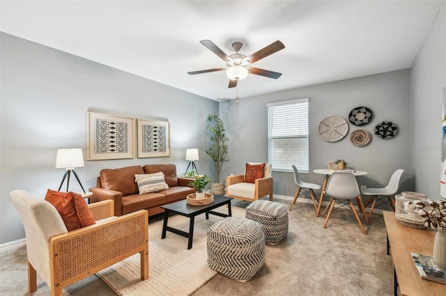 carpeted living room with a ceiling fan and baseboards