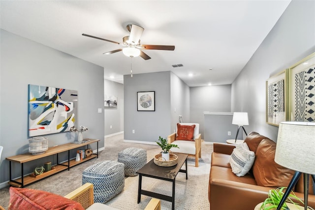 living area with visible vents, baseboards, carpet, and ceiling fan