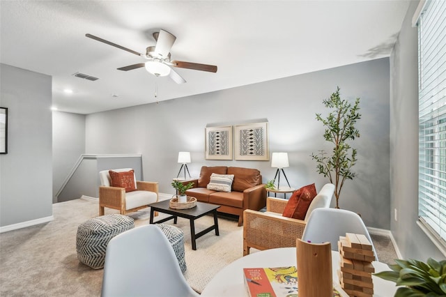 living room featuring visible vents, baseboards, carpet, and a ceiling fan