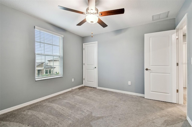 unfurnished bedroom with carpet, visible vents, and baseboards