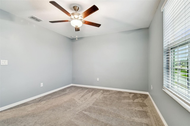 empty room featuring visible vents, baseboards, a ceiling fan, and carpet flooring