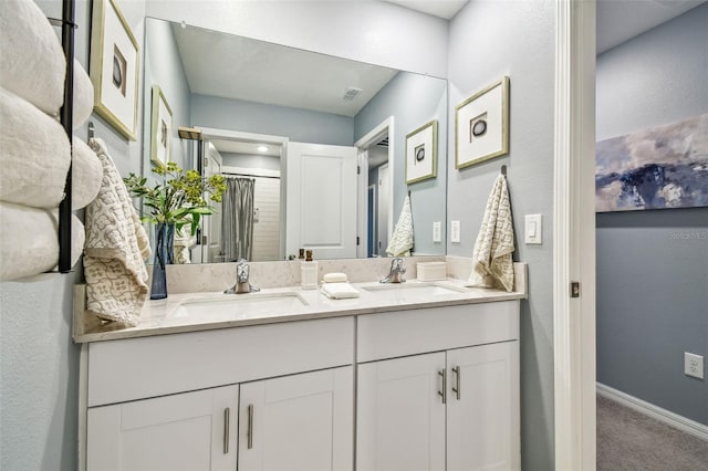 full bathroom featuring double vanity, visible vents, baseboards, and a sink