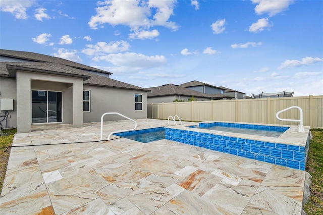 view of swimming pool featuring a fenced in pool, a jacuzzi, a patio, and fence