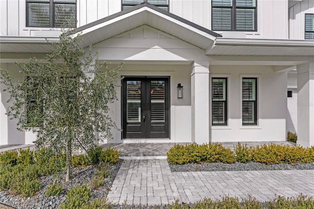 entrance to property featuring covered porch, french doors, and board and batten siding