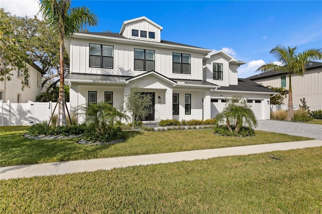 view of front facade with a garage, a standing seam roof, fence, decorative driveway, and a front lawn