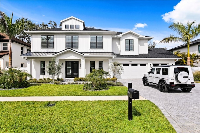 view of front of property with a garage, metal roof, a standing seam roof, decorative driveway, and a front yard