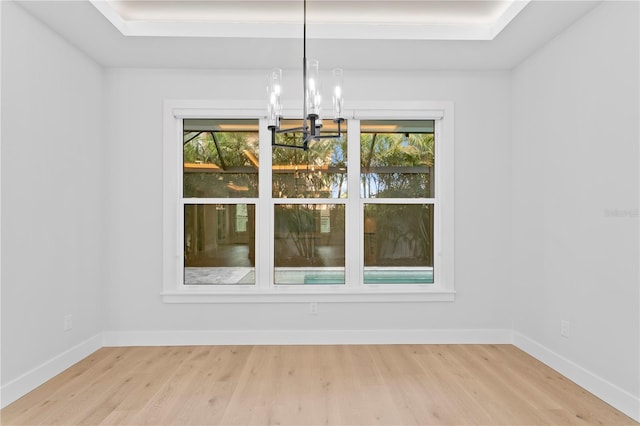 unfurnished dining area with a wealth of natural light, baseboards, and wood finished floors