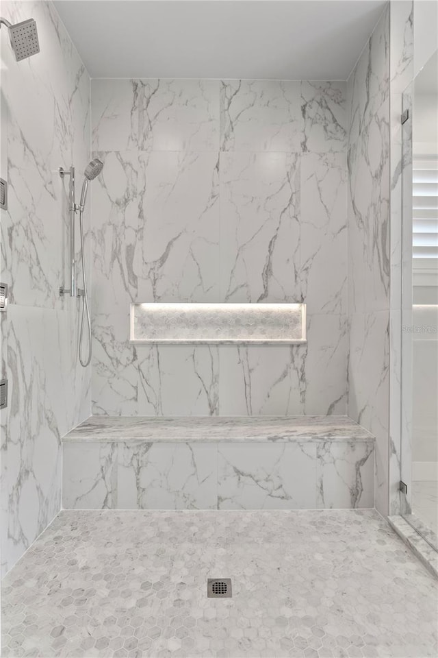 full bathroom featuring a marble finish shower