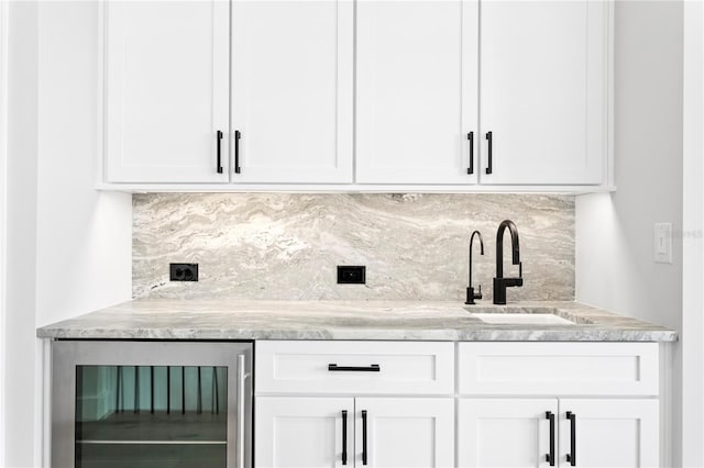 bar featuring wine cooler, a sink, and tasteful backsplash