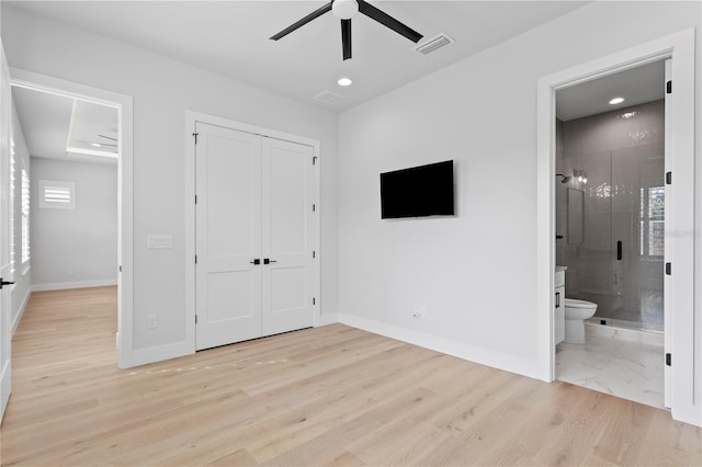 unfurnished bedroom featuring light wood finished floors, a closet, visible vents, ensuite bath, and baseboards