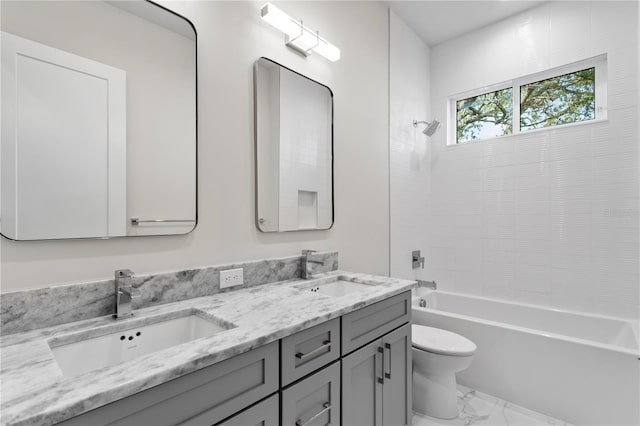 bathroom featuring marble finish floor, double vanity, a sink, and toilet