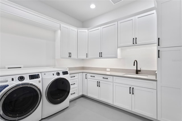 clothes washing area featuring recessed lighting, separate washer and dryer, a sink, visible vents, and cabinet space