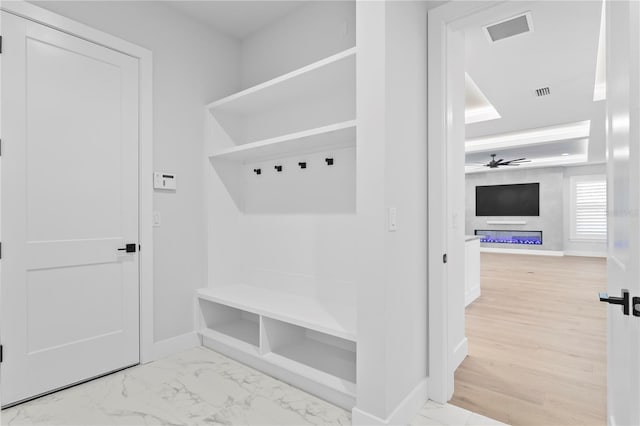 mudroom with marble finish floor, baseboards, and visible vents