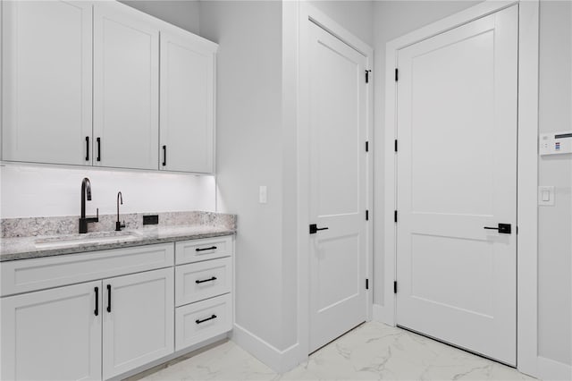 bathroom with marble finish floor, baseboards, and vanity