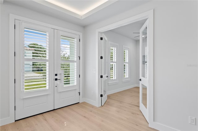 foyer with light wood-type flooring, french doors, and baseboards