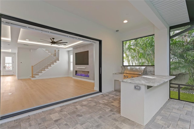 kitchen featuring recessed lighting, a large fireplace, ceiling fan, a peninsula, and baseboards