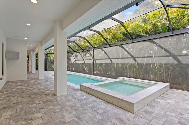 pool with a patio, a lanai, and an in ground hot tub