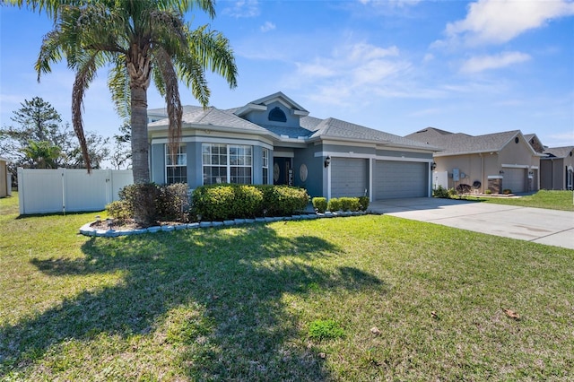 view of front of house with concrete driveway, an attached garage, fence, and a front yard