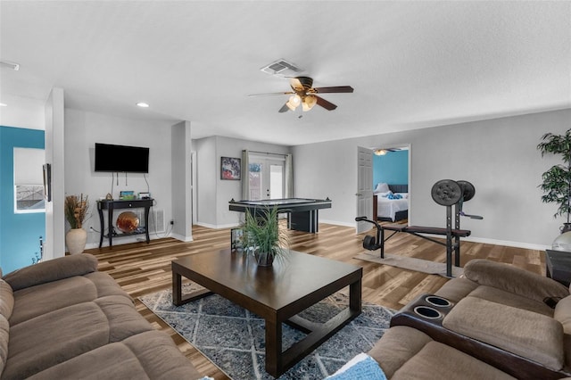 living room with wood finished floors, visible vents, baseboards, a ceiling fan, and french doors