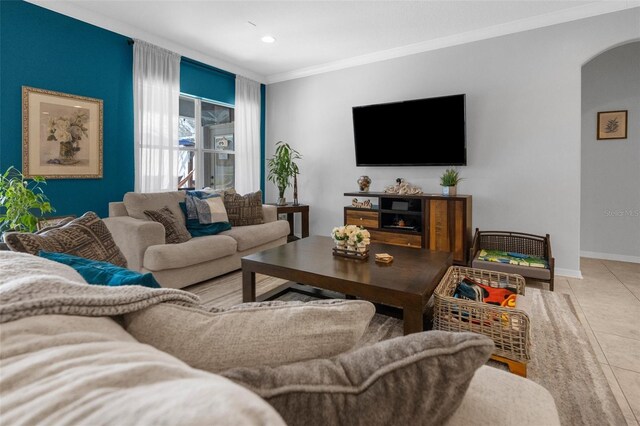 tiled living room featuring baseboards, arched walkways, crown molding, and recessed lighting