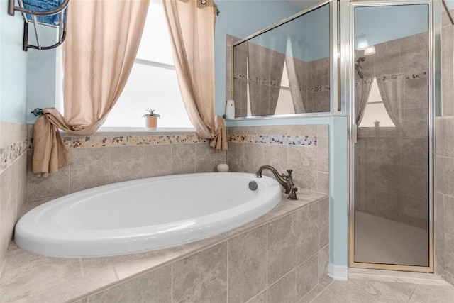 bathroom with a shower stall, a bath, and tile patterned floors