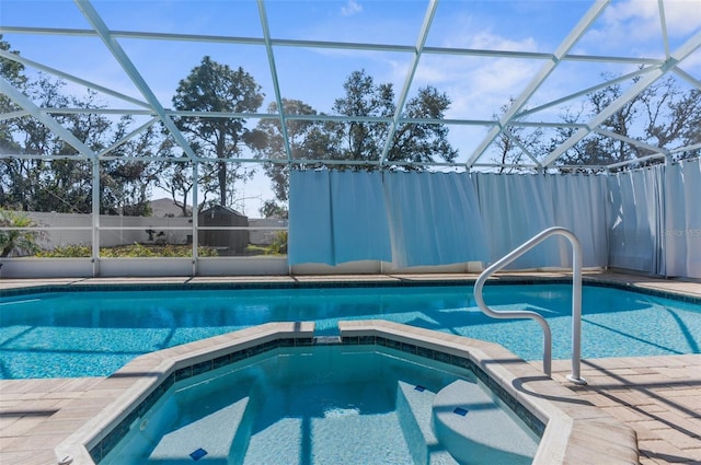 view of pool with a pool with connected hot tub and a lanai