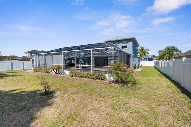 back of property featuring glass enclosure, a lawn, a fenced backyard, and an outdoor pool