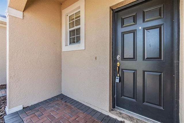 property entrance featuring stucco siding