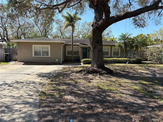 ranch-style house with fence and stucco siding