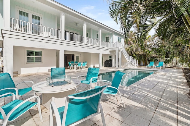 view of swimming pool featuring an outdoor fire pit, a fenced in pool, outdoor dining area, a patio area, and stairs