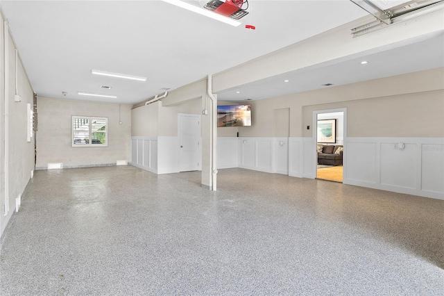 garage featuring a wainscoted wall and a decorative wall