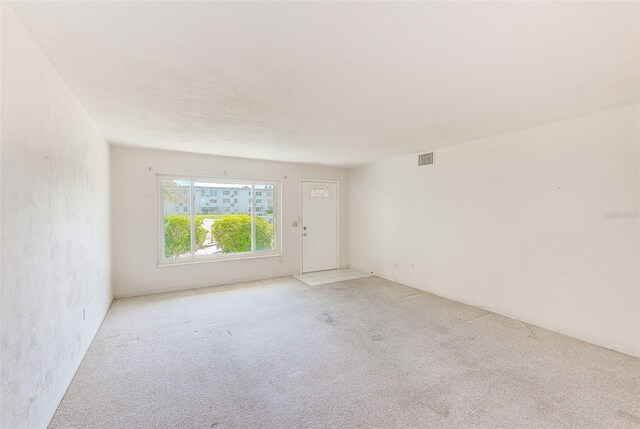 unfurnished room with visible vents and light colored carpet