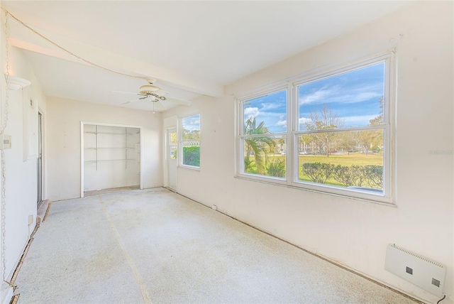 unfurnished bedroom with beamed ceiling, a closet, and a ceiling fan