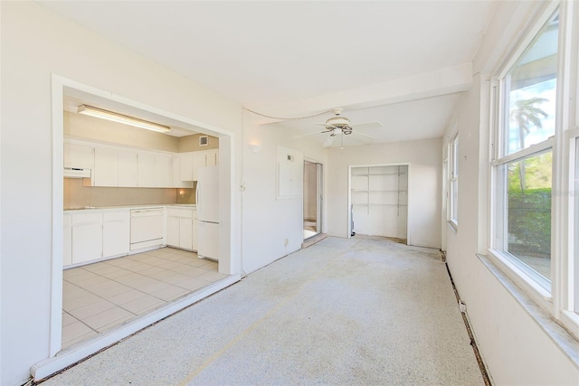 spare room with light speckled floor, visible vents, and a ceiling fan