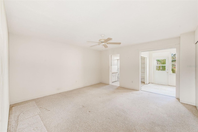 empty room featuring baseboards, a ceiling fan, and light colored carpet