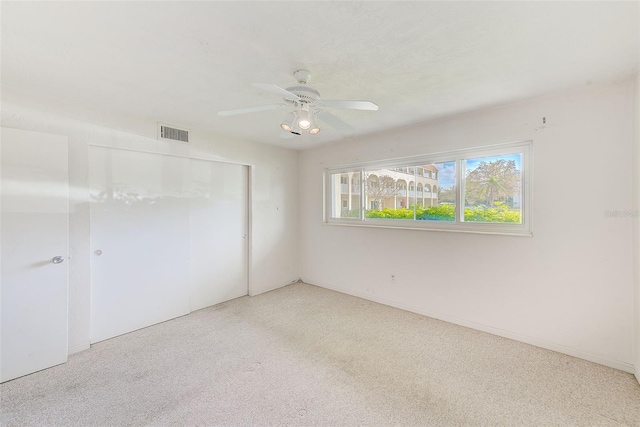 unfurnished bedroom featuring a ceiling fan, a closet, and visible vents