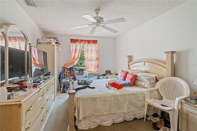 carpeted bedroom with a ceiling fan, visible vents, and a textured ceiling