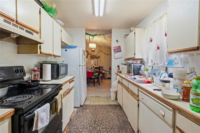 kitchen with a notable chandelier, light countertops, white cabinetry, under cabinet range hood, and black appliances