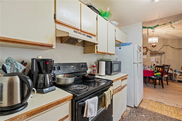 kitchen featuring black electric range, light countertops, freestanding refrigerator, and under cabinet range hood