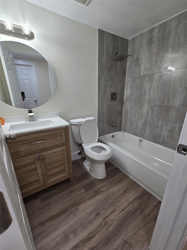 full bathroom with a textured wall, toilet, vanity, a textured ceiling, and wood finished floors