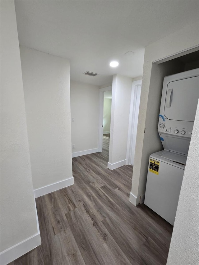 washroom featuring laundry area, wood finished floors, visible vents, baseboards, and stacked washer and clothes dryer