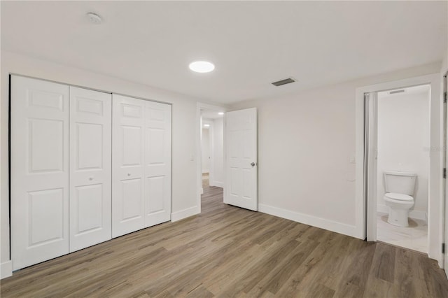 8319 N 14th St, Tampa, FL 33604 - unfurnished bedroom featuring light wood-style flooring, baseboards, a closet, and connected bathroom