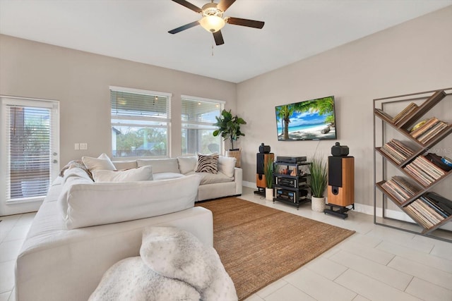 living area with ceiling fan, tile patterned floors, and baseboards