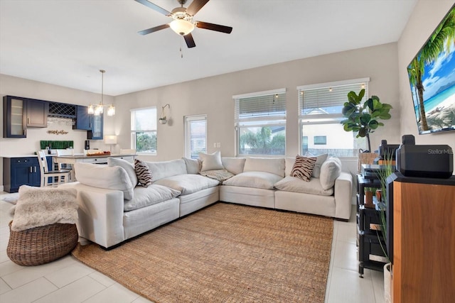 living room featuring light tile patterned floors and ceiling fan with notable chandelier