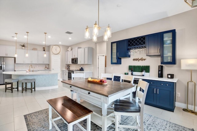 kitchen with stainless steel appliances, light countertops, visible vents, and blue cabinets