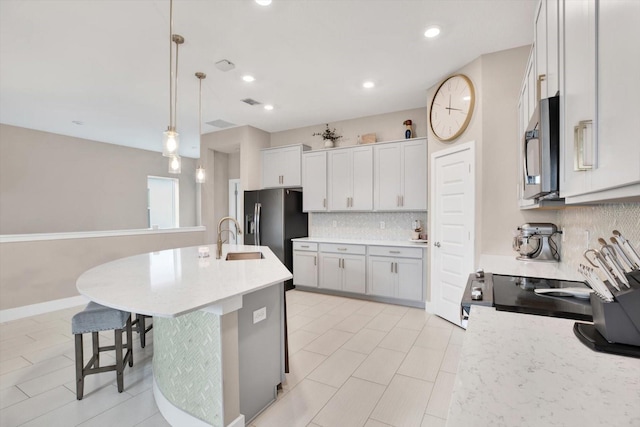 kitchen with decorative backsplash, electric range oven, decorative light fixtures, refrigerator with ice dispenser, and a sink