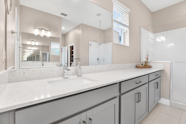 full bath with a healthy amount of sunlight, a stall shower, visible vents, and vanity